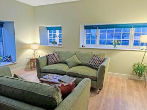 a living room with two couches and a table at Bracken At Holly House - Uk44469 in Newton