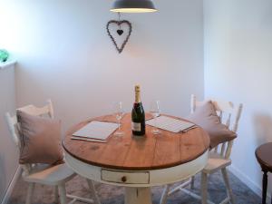 a table with a bottle of wine and glasses on it at Sea Thistle Cottage in Nairn
