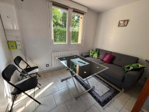 a living room with a glass table and a couch at Gîte de Daniel in Huppy