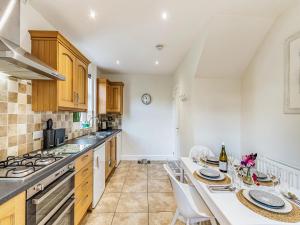 a kitchen with a table and a stove top oven at Heughendon in Rothbury +6 photos