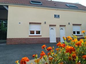 a building with orange flowers in front of it at Gîte de Daniel in Huppy