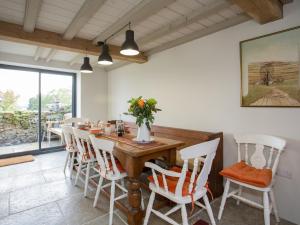 une salle à manger avec une table en bois et des chaises blanches dans l'établissement Lyndhurst Cottage, à Carlton 19 autres photos