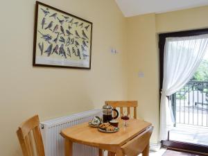 a wooden table with a tea kettle on it next to a window at Wee Cordorcan - Uk5890 in Bargrennan