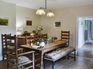 a dining room with a wooden table and chairs at The Garden Cottage in Rudston