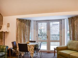 una sala de estar con un sofá y una mesa en Pine Tree Cottage - Uk45925, en Ballater