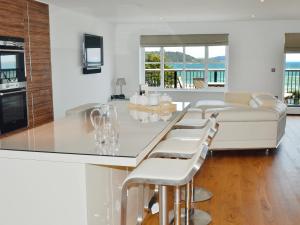 cocina blanca con encimera y sofá en Gylly Beach View - Tor, en Falmouth