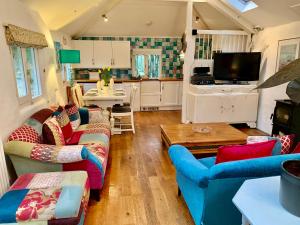 a living room with two couches and a table at Chapel Barn in Bodmin