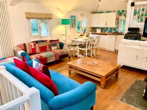 a living room with a blue couch and a table at Chapel Barn in Bodmin
