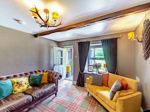 a living room with a couch and a chandelier at Holme House in Eldroth