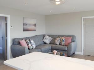 Una sala de estar con un sofá con almohadas. en Crows Nest, en Bridlington