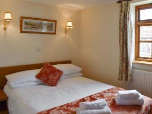 a bedroom with a bed with two towels on it at The Milking Parlour in Sidbury