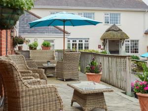 a group of chairs and an umbrella on a patio at The Milking Parlour in Sidbury +14 photos