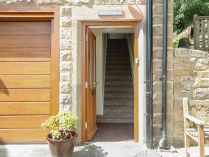 una escalera que conduce a una casa con puerta de madera en Netherwood, en Bakewell 5 fotos más