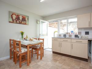 a kitchen with a table and chairs in a room at Jubilee Cottage in Dawlish
