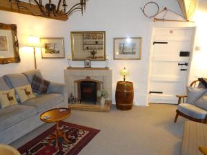 a living room with a couch and a fireplace at The Old Coach House in Thornton