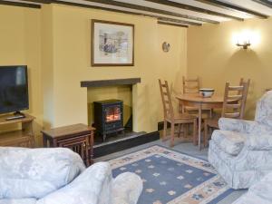 Una sala de estar con chimenea y una mesa y sillas. en Chaffcuttters, en East Down
