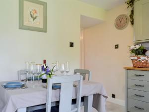 a dining room with a table with chairs and a clock at Keldholme Cottages 2 - Uk11488 in Kirkbymoorside