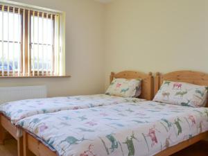 una camera da letto con un letto con un piumone e due cuscini di Stepen Cottage a Chard