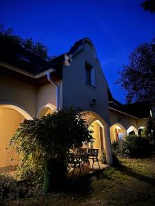 una casa con un tavolo in cortile di notte di Tulipános Ház a Velence