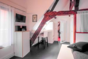 a living room with a desk and a tv in a attic at Mons Dragon House in Mons