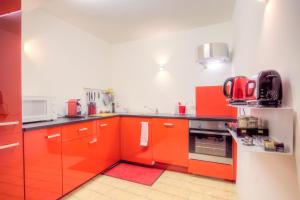 a kitchen with orange cabinets and a stove at Mons Dragon House in Mons
