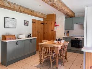 a kitchen with a wooden table and chairs at Barn End Cottage in Millers Dale