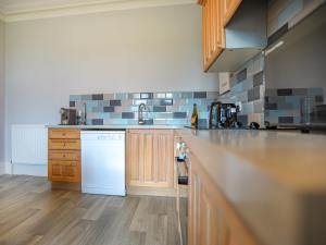 a kitchen with a counter and a white dishwasher at Oak - Uk38687 in Bideford