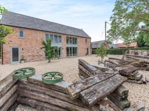 a barn conversion with a wooden fence and a building at Heron's Den - Uk44529 in Horncastle