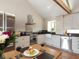 una cocina con una mesa con una bandeja de comida y copas de vino en Property 2, en Ventnor