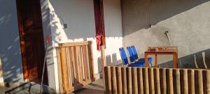 a room with a table and blue chairs and a fence at Tetebatu Terrace Hostel in Tetebatu