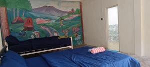 a room with two beds and a mural on the wall at Tetebatu Terrace Hostel in Tetebatu