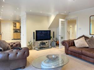 a living room with two couches and a tv at Littlewood Gardens in Montrose