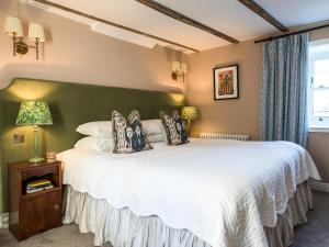 a bedroom with a large white bed with a green wall at Auchengool House in Kirkcudbright +12 photos