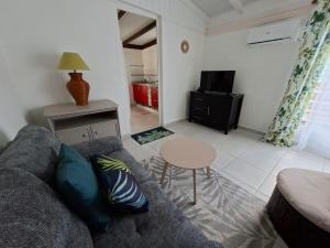 a living room with a couch and a table at Charmant F2 créole in Sainte-Luce