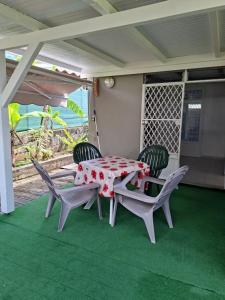 a table and chairs on the porch of a house at Charmant F2 créole in Sainte-Luce