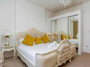 a bedroom with a white bed with yellow pillows at The Downs in Torquay