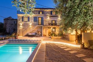 a house with a swimming pool in front of a house at Villa pero -an artists home in Ždrelac