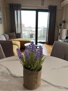 a vase with purple flowers sitting on a table at Luxury Apartment 52 Diamond Residences in Skopje
