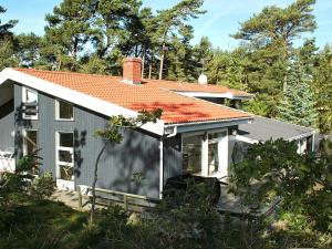 a small white house with an orange roof at 12 person holiday home in Nexø in Snogebæk