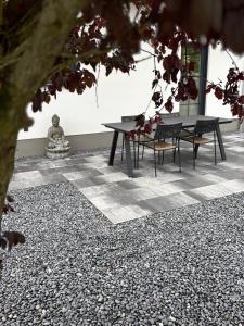 LingerhahnにあるHunsrückGlück Ferienhaus am Schinderhannes-Radwegのテーブルと椅子の隣に座っている仏像