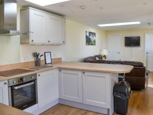 a kitchen with white cabinets and a counter top at Sherwood Forest Lodge 1 in Clipstone