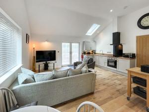 a living room with a couch and a kitchen at Wyn Shiels Hide Away in Ainstable