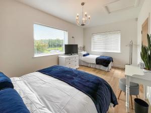 a bedroom with two beds and a desk and a television at Wyn Shiels Hide Away in Ainstable +3 photos