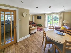 a living room with a table and a couch at Duck Cottage in Winterbourne Dauntsey