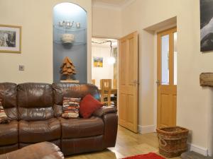 a living room with a brown leather couch in a room at Chartfield in Windermere