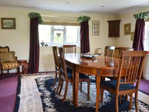 a dining room with a wooden table and chairs at Glebe Farm Cottage in Hornby