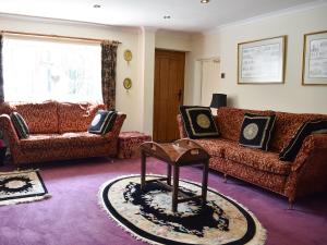 a living room with two couches and a table at Glebe Farm Cottage in Hornby