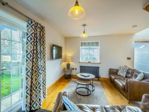 un soggiorno con un divano e un tavolo di Deri Cottage a Chwilog