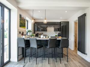 a kitchen with a large black island with chairs at Brook Cottage-Uk44378 in Washford