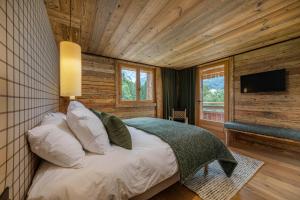Un dormitorio con una cama en una habitación con paredes de madera. en La Ferme, en Le Fernuy